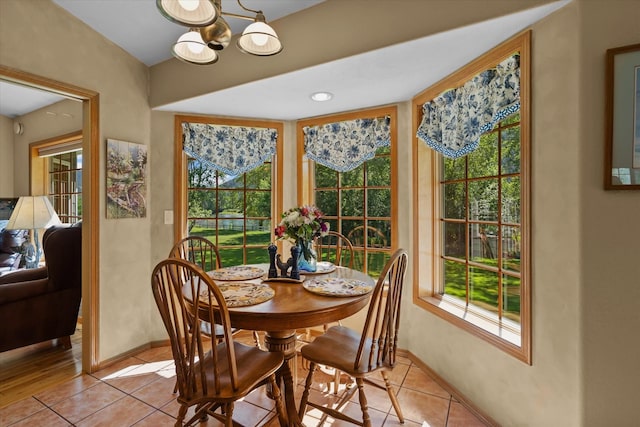 tiled dining space with a chandelier