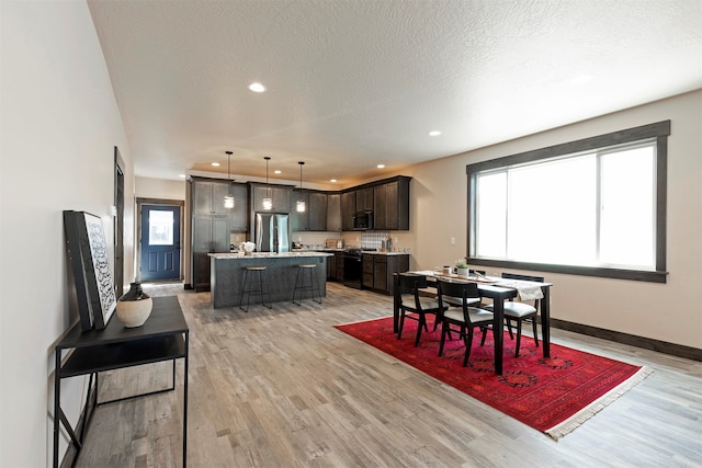 dining room featuring light hardwood / wood-style flooring and a textured ceiling