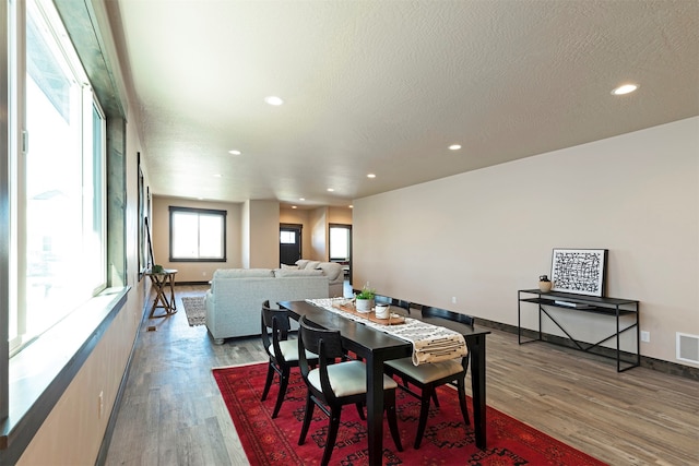 dining space featuring hardwood / wood-style floors and a textured ceiling