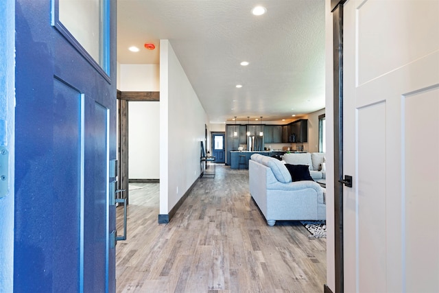 interior space featuring light wood-type flooring and a textured ceiling