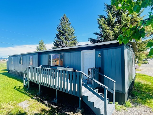 back of house featuring a lawn and a deck