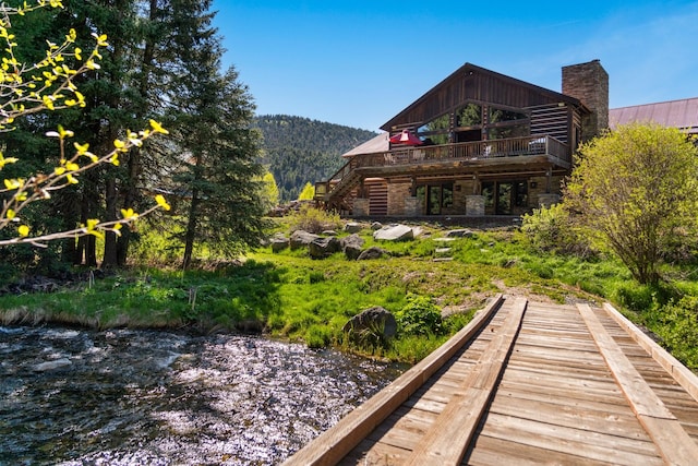 back of property with a water and mountain view