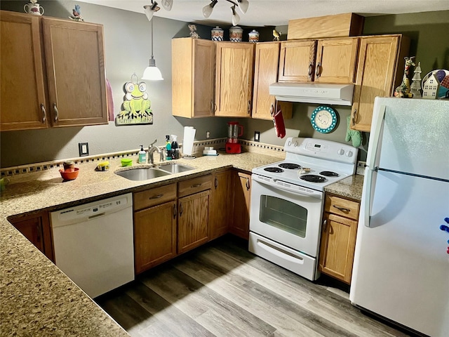 kitchen with pendant lighting, wood-type flooring, white appliances, and sink