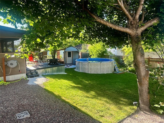 view of yard with a swimming pool side deck and a storage unit