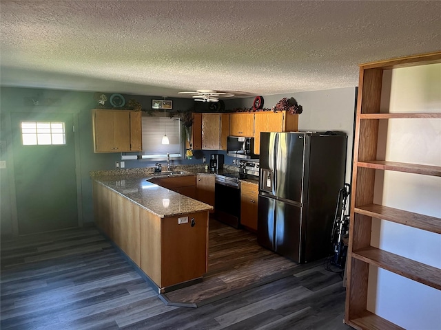 kitchen with kitchen peninsula, a textured ceiling, stainless steel appliances, sink, and dark hardwood / wood-style floors