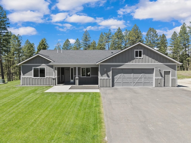 ranch-style home featuring a garage and a front lawn