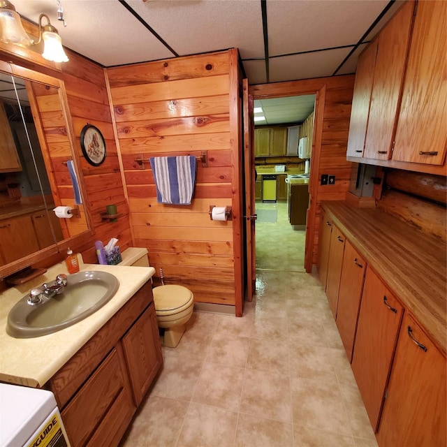 15426 Steamboat Dr, Augusta, MT 59410 - bathroom featuring toilet, vanity, wooden walls, and a paneled ceiling