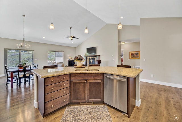 kitchen with sink, hanging light fixtures, dishwasher, and a center island with sink