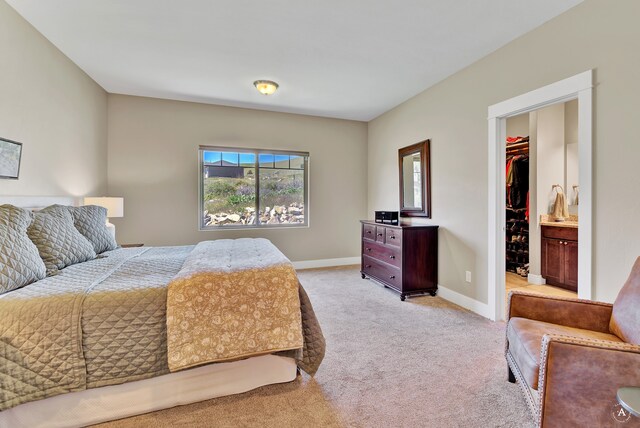 carpeted bedroom featuring multiple windows, a spacious closet, ensuite bath, and a closet