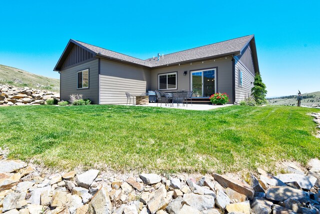 rear view of property with a yard and a patio area