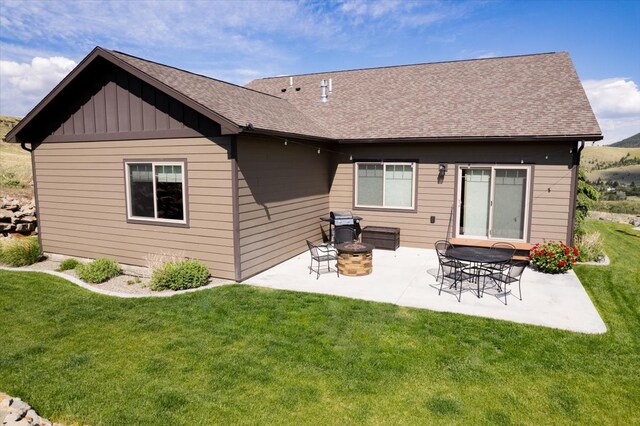 rear view of house with a yard, a patio area, and a fire pit