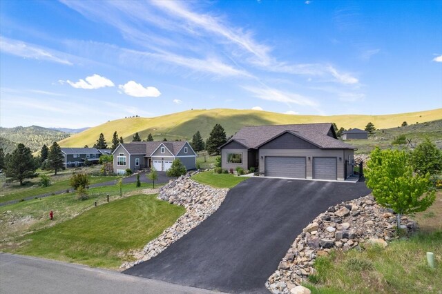 view of front of house featuring a mountain view, a garage, and a front yard