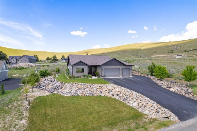 ranch-style home featuring a mountain view, a garage, and a front lawn