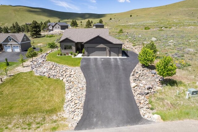 view of front of property with a garage, a mountain view, and a front yard