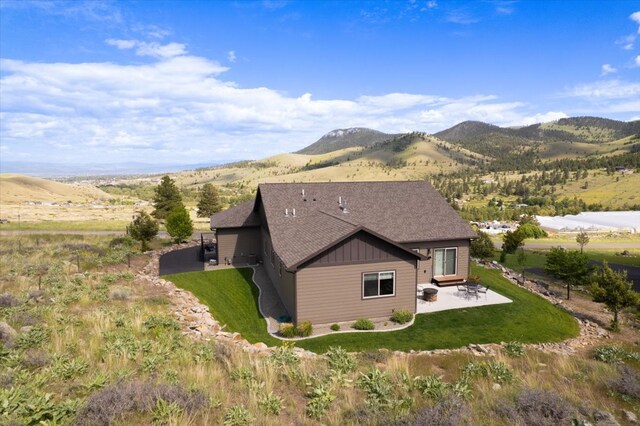 exterior space with a mountain view, a patio area, and a lawn