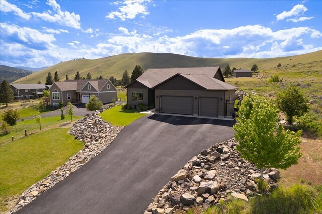 view of front of property featuring a mountain view, a garage, and a front lawn