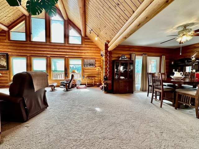 carpeted living room with plenty of natural light, wood ceiling, rustic walls, and high vaulted ceiling