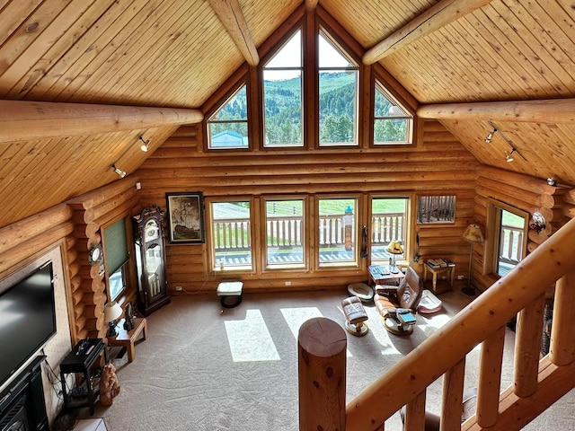 unfurnished living room featuring beam ceiling, rustic walls, and high vaulted ceiling