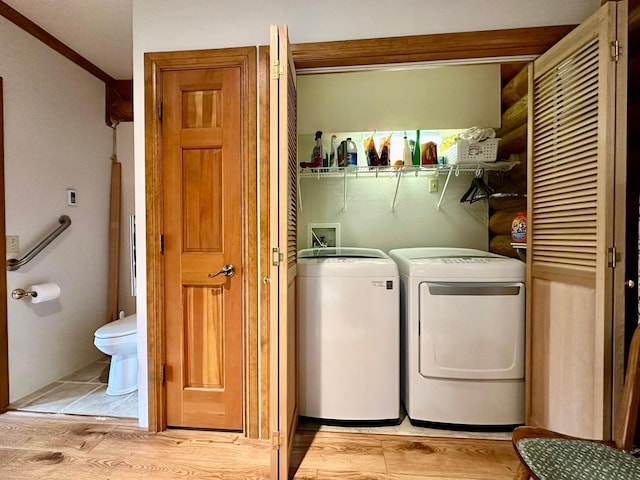 laundry area featuring washing machine and clothes dryer and light wood-type flooring