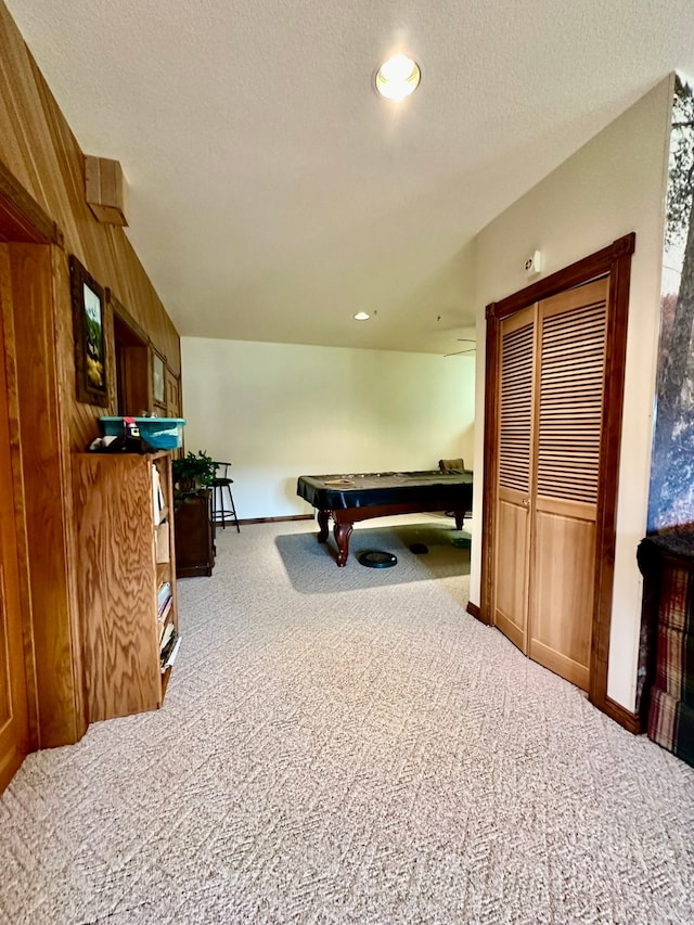 game room featuring carpet flooring, wooden walls, a textured ceiling, and pool table