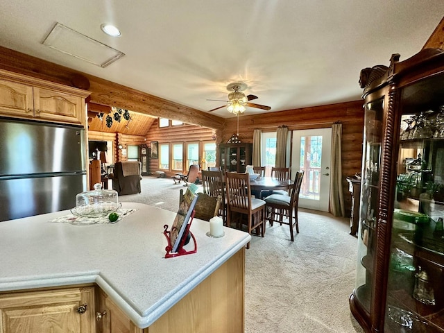 kitchen with stainless steel refrigerator, ceiling fan, log walls, and light colored carpet