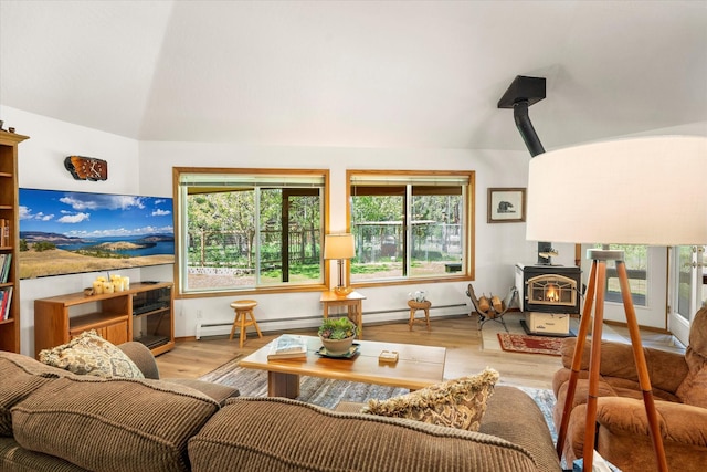 living room featuring light wood-type flooring, a baseboard radiator, a wood stove, and lofted ceiling