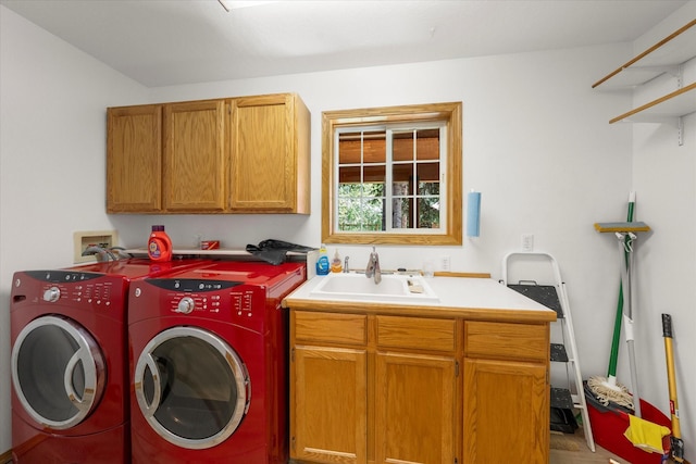 clothes washing area featuring separate washer and dryer, sink, and cabinets