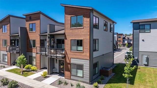 contemporary house featuring a front yard and a balcony