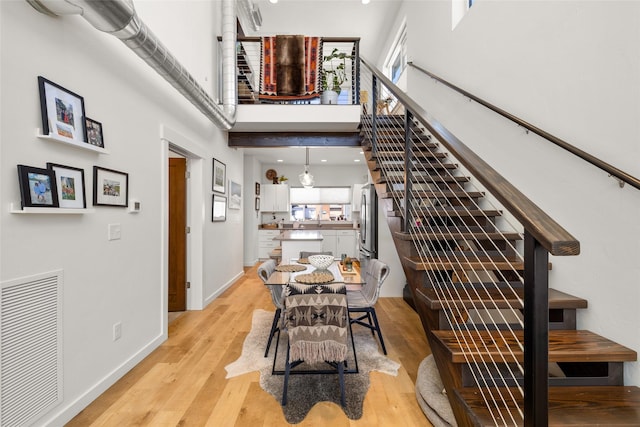 281 Blackberry Loop Unit A, Whitefish, MT 59937 - dining room featuring stairs, a towering ceiling, light wood-style floors, and baseboards