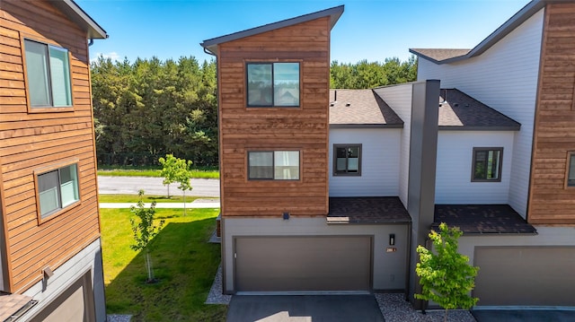 281 Blackberry Loop Unit A, Whitefish, MT 59937 - view of front facade featuring a shingled roof, a garage, concrete driveway, and a front lawn
