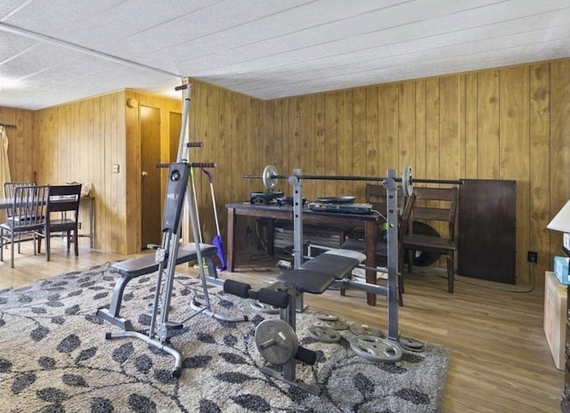 exercise room with hardwood / wood-style flooring and wooden walls