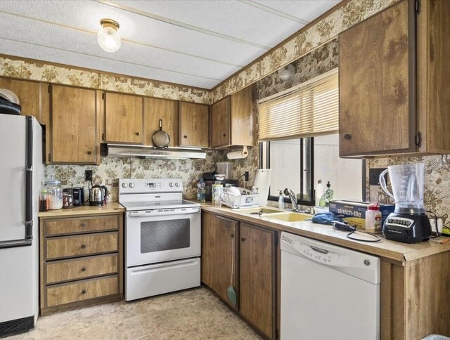 kitchen with white appliances, light tile patterned floors, backsplash, extractor fan, and sink