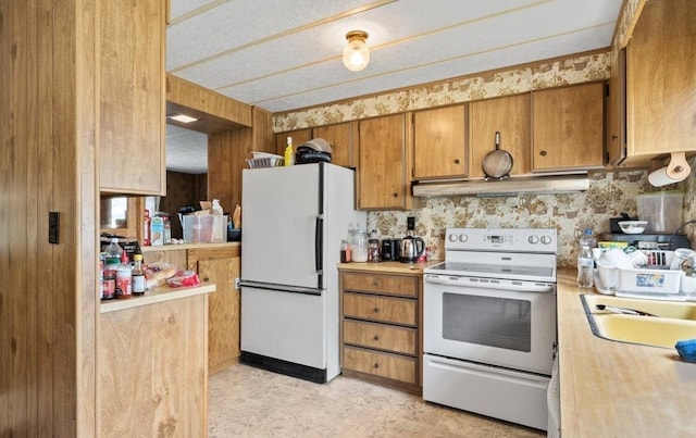 kitchen with white appliances, sink, light tile patterned floors, a textured ceiling, and exhaust hood