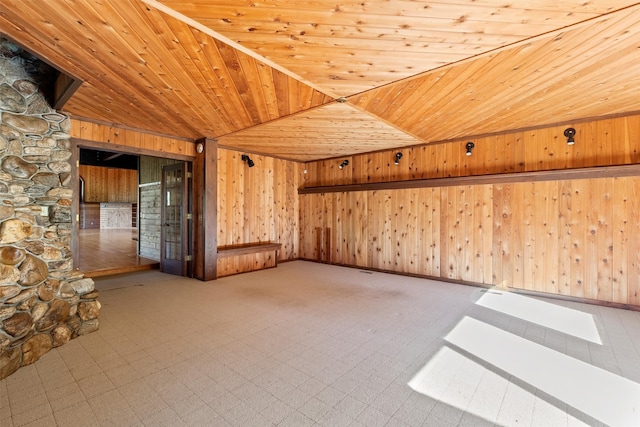 tiled empty room with vaulted ceiling, wooden walls, and wood ceiling