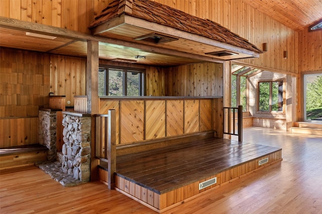 interior space with beamed ceiling, wooden walls, hardwood / wood-style flooring, and wood ceiling