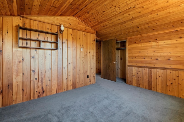 carpeted empty room featuring wood walls, lofted ceiling, and wooden ceiling