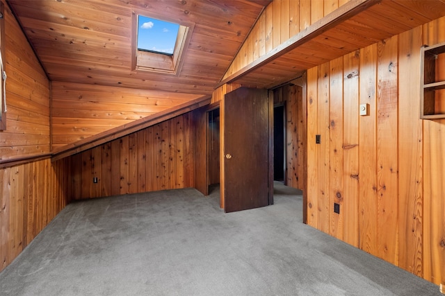 additional living space featuring wooden ceiling, wooden walls, lofted ceiling with skylight, and light colored carpet