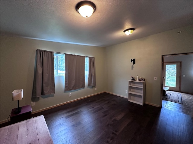 spare room featuring dark hardwood / wood-style floors and a wealth of natural light