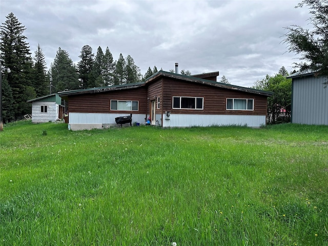 back of property featuring a lawn