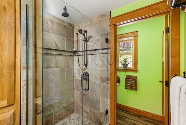 bathroom with a shower stall, baseboards, and wood finished floors