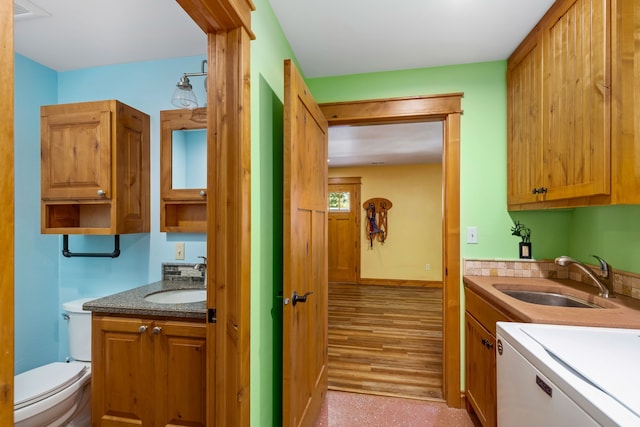 interior space with range, baseboards, brown cabinets, and a sink