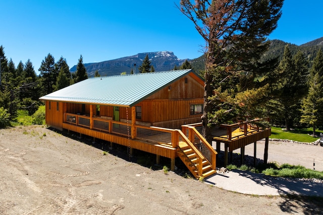 view of front of house with metal roof, a standing seam roof, and a mountain view