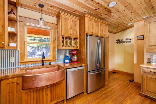 kitchen with appliances with stainless steel finishes, a sink, wood ceiling, and light wood-style floors