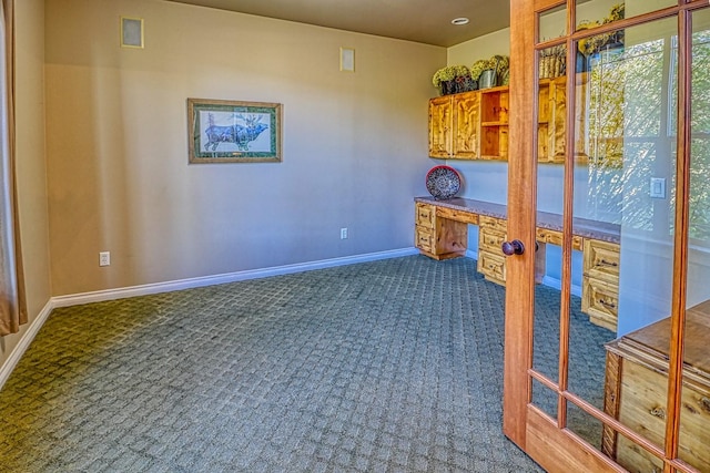 carpeted office space with built in desk