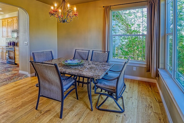 dining area with an inviting chandelier and light hardwood / wood-style floors