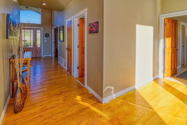 hall featuring a high ceiling and wood-type flooring