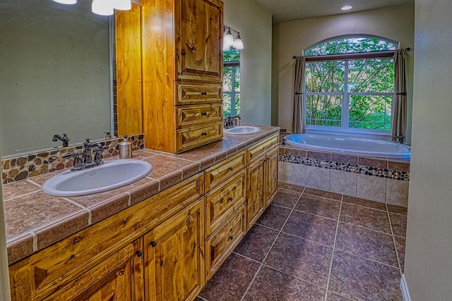 bathroom with tiled tub and vanity