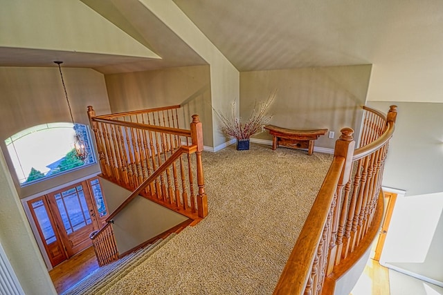 staircase with vaulted ceiling and carpet floors