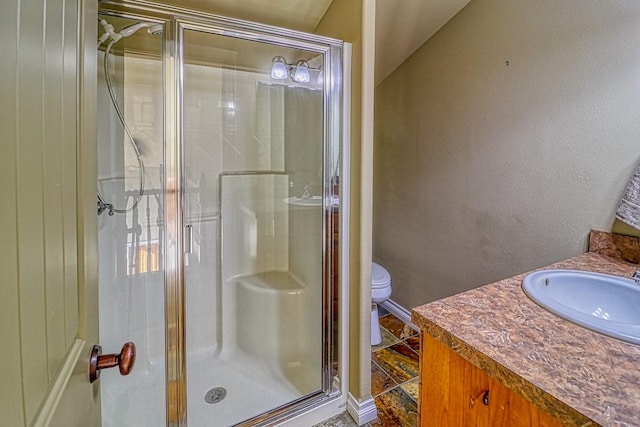 bathroom with an enclosed shower, vanity, and toilet