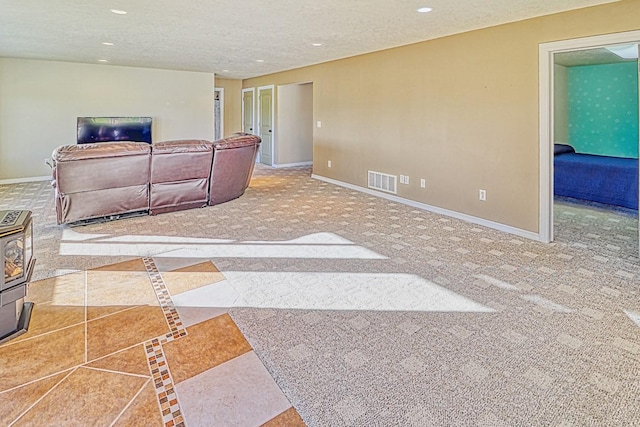 carpeted living room featuring a textured ceiling and a wood stove